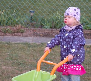 Sophie im Garten mit der Schubkarre